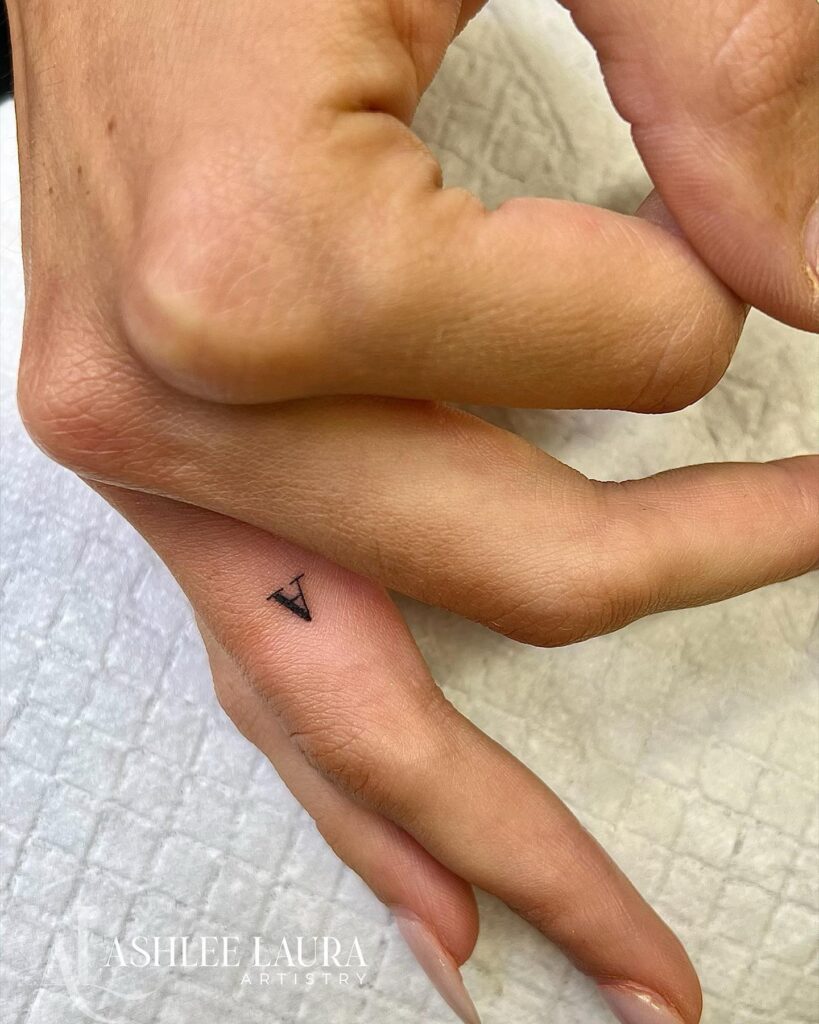 A letter tattoo on the side of the ring finger, a cute and personal touch: initial whimsy 