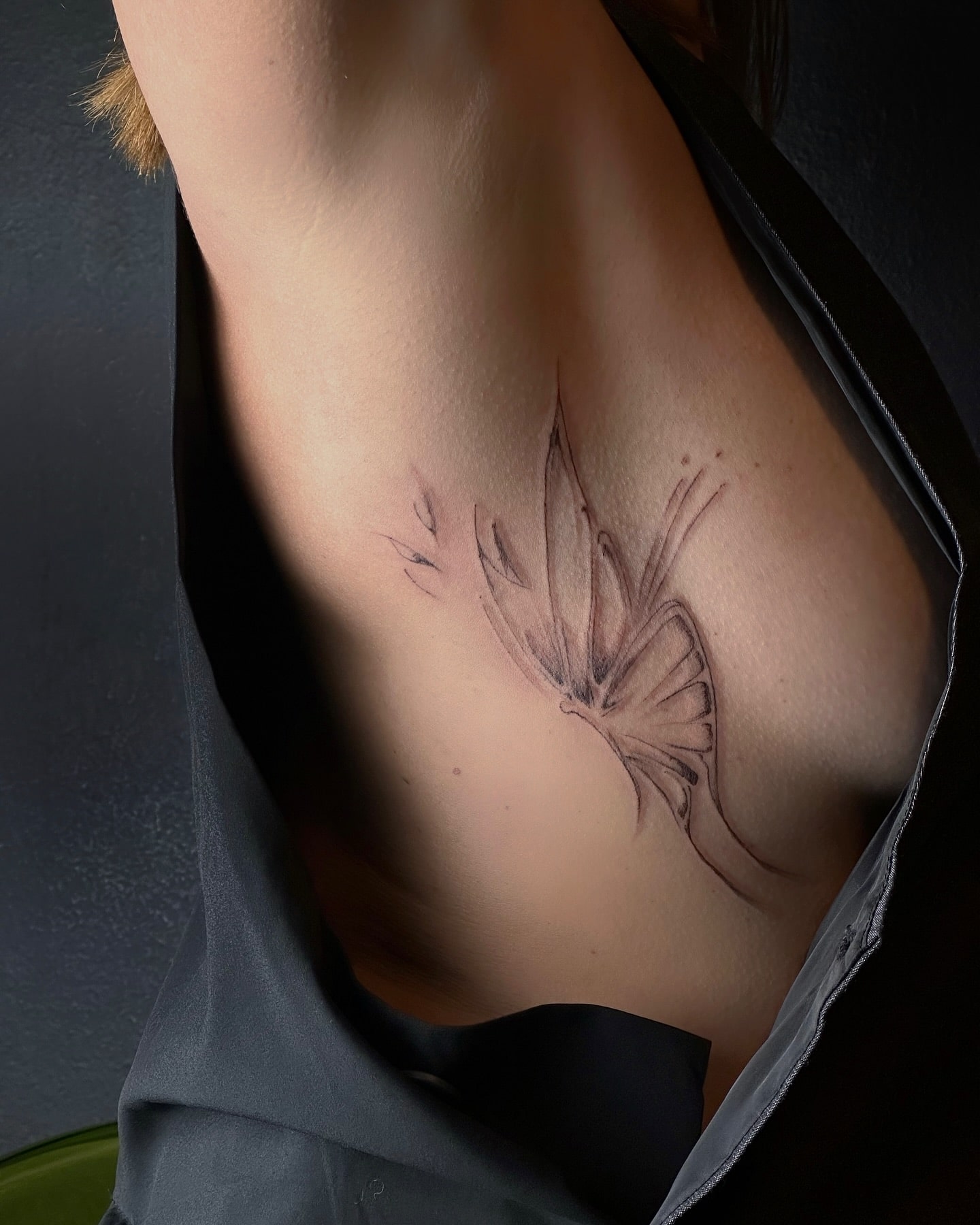 Abstract side ribcage butterfly tattoo with sketch-style linework 