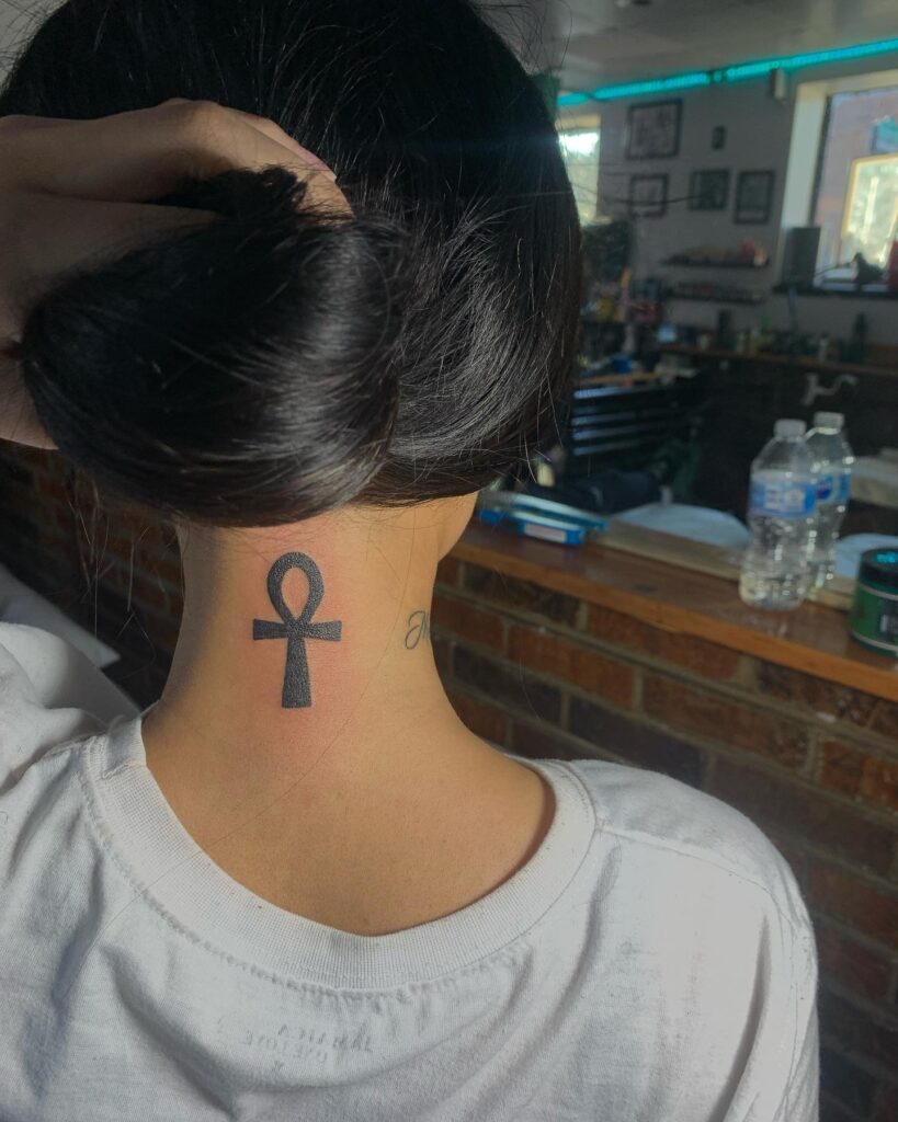 Ancient egyptian elegance ankh tattoo on the back of a girls neck 