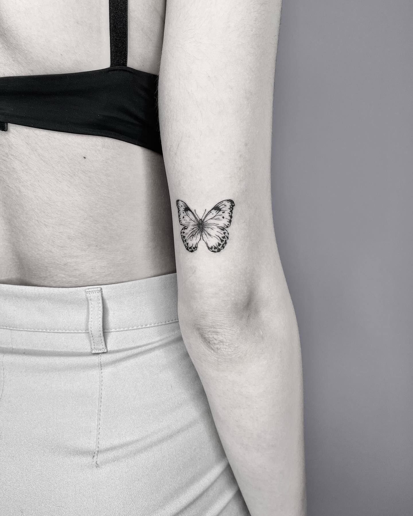 Black and grey butterfly tattoo outer arm above elbow ideas 