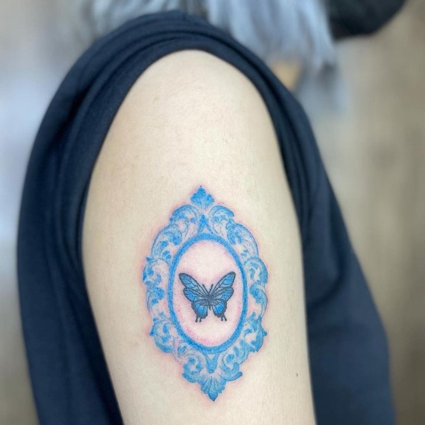 Blue butterfly inside a mirror tattoo design