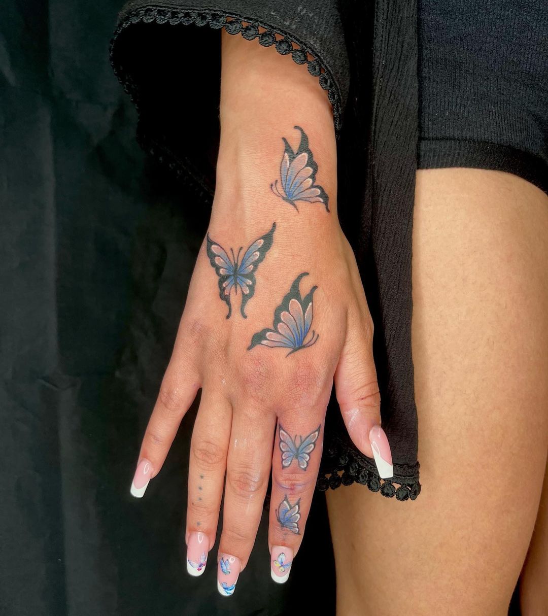 Blue butterfly with black outlines on the fingers&nbsp;