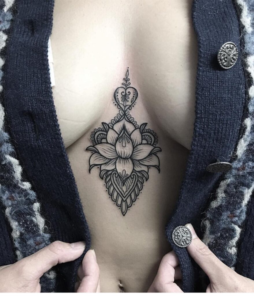 Bold lotus and heart sternum tattoo with mandala-inspired details 