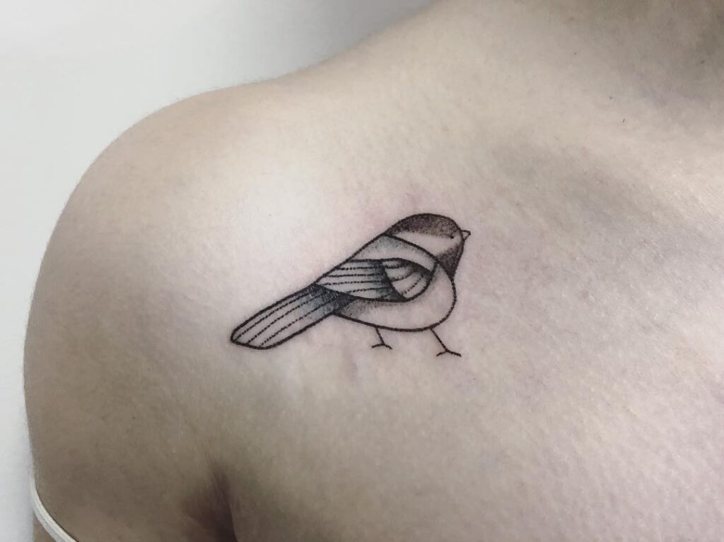 Chubby chickadee tattoo on the collarbone, a playful black and grey art chirpy charm 