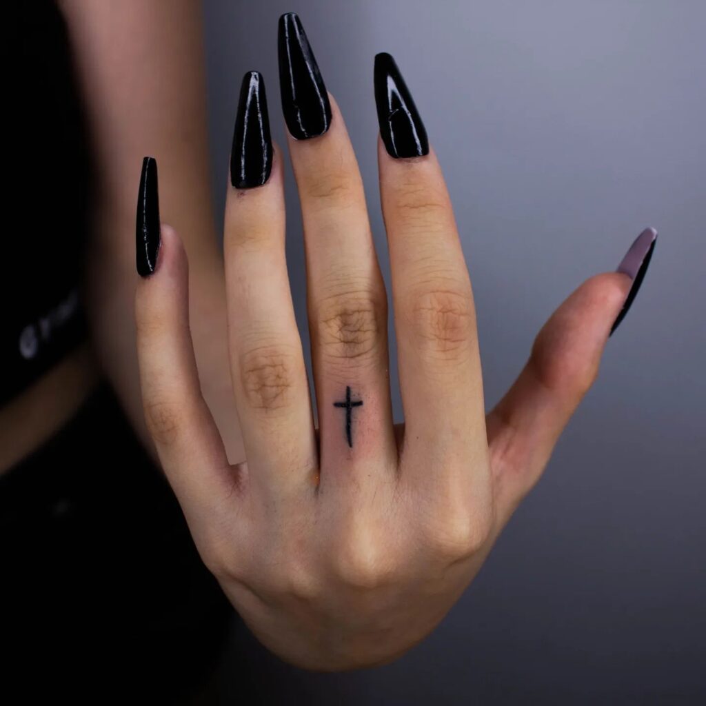 Cross Tattoo on the Middle Finger Crafted in Blackwork Ink for a Bold Symbol of Faith: Divine Faith 