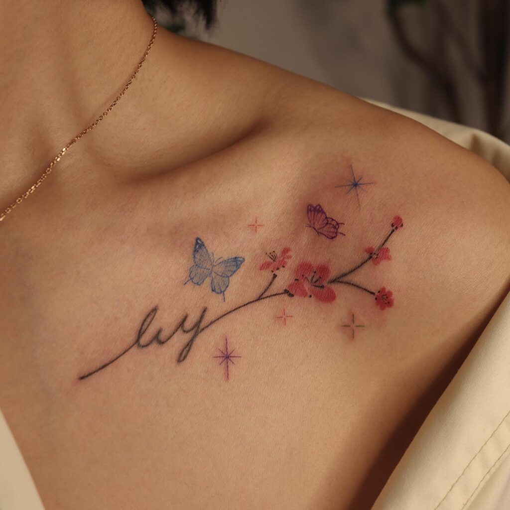 Flower, star, and butterfly tattoo on female shoulder 