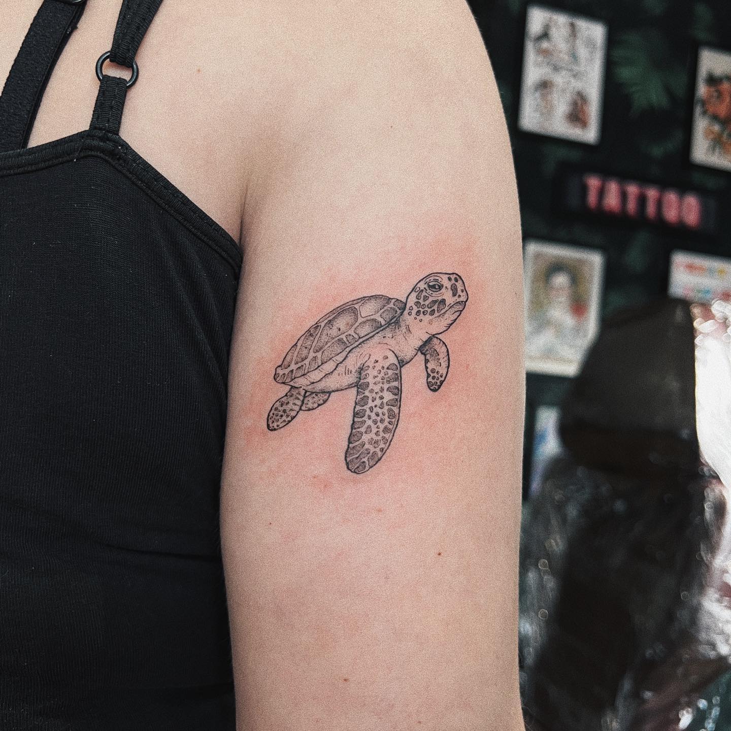 Highly detailed realistic sea turtle tattoo with intricate fine-line work and smooth shading on the upper arm for a lifelike appearance 