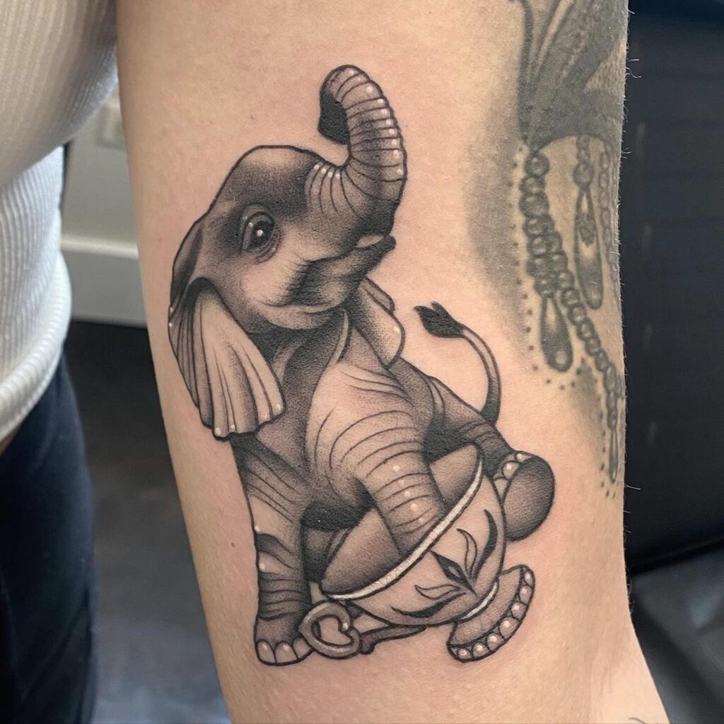 Illustrative baby elephant tattoo with playful leg pose: teacup playfulness 