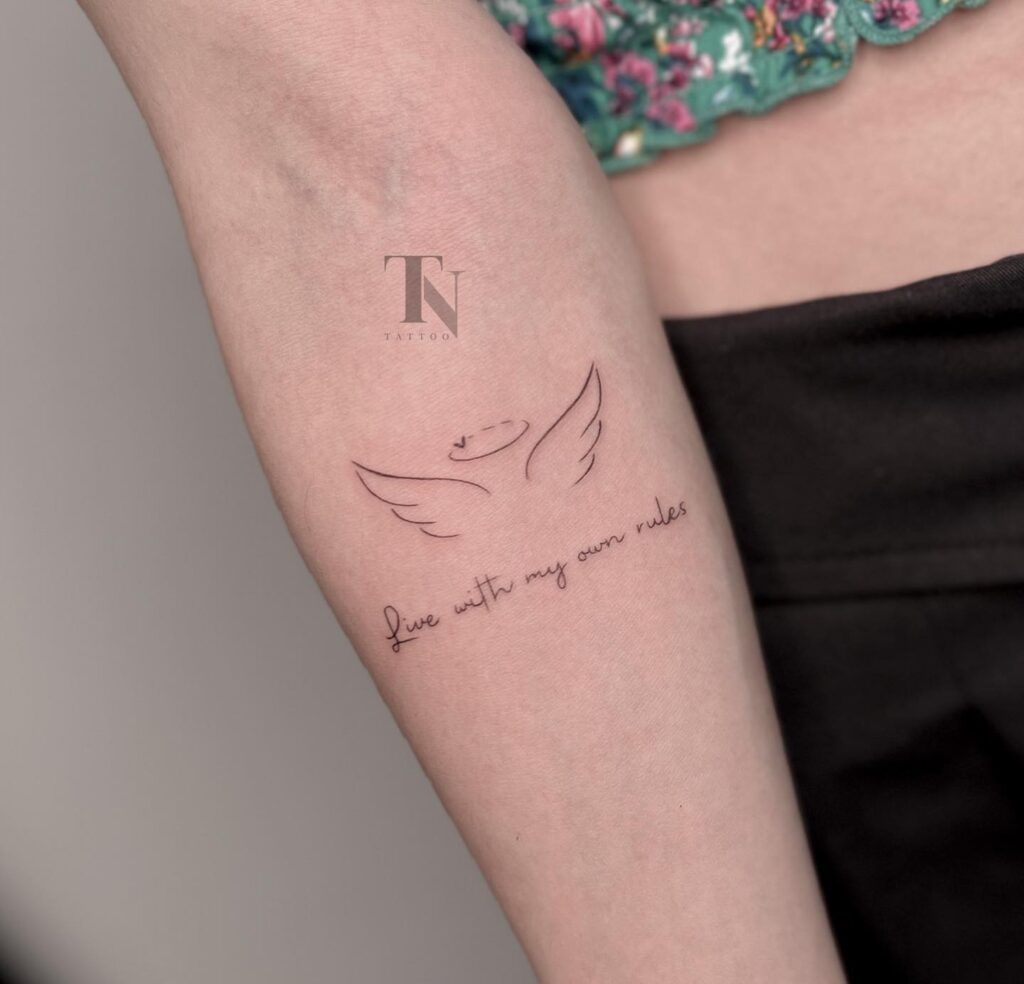 Inner Forearm Angel Wing Tattoo with 'Live with My Own Rules' Text Below: Ink of Freedom 