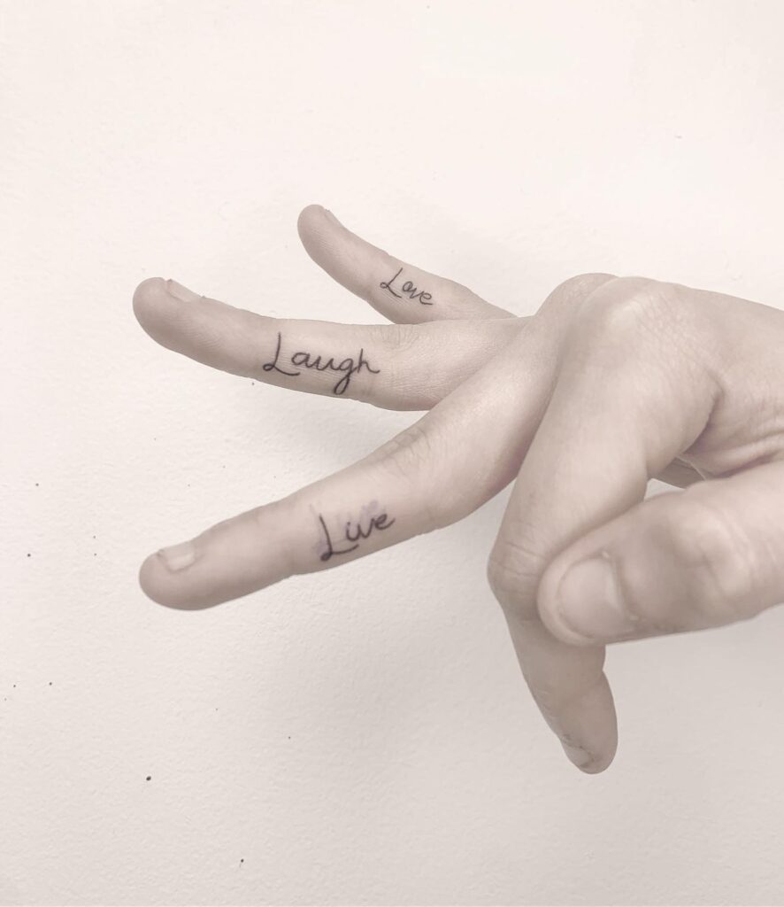 Live on one finger laugh on another love on another finger tattoo 