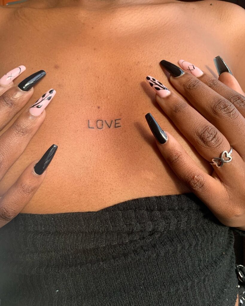 Minimalist LOVE chest tattoo simple lettering design for self-love 