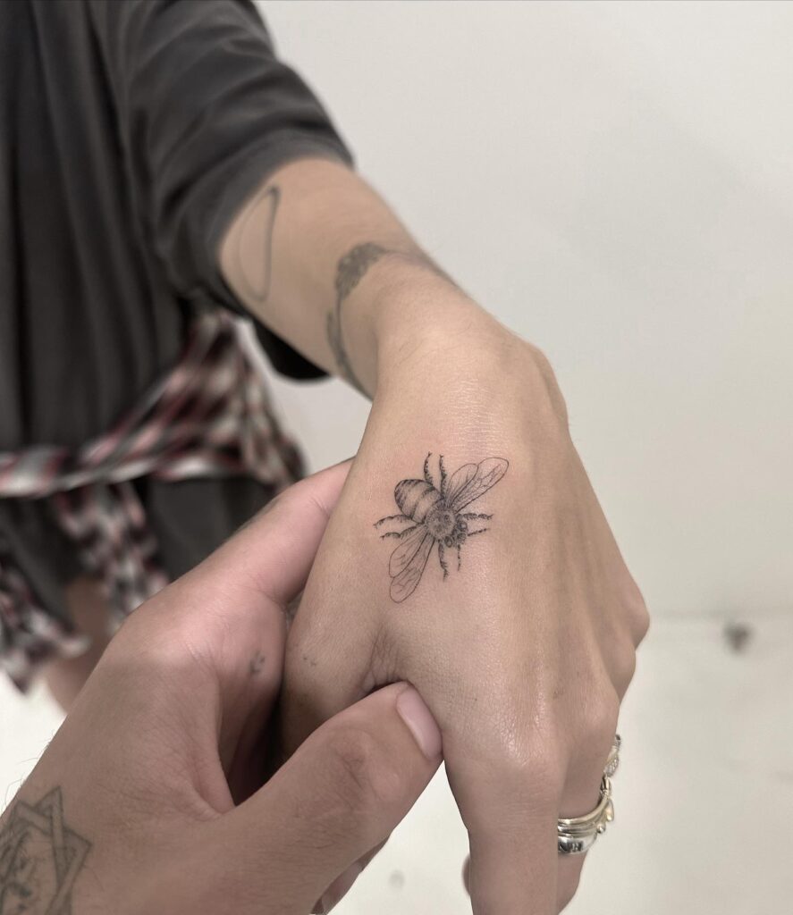 Minimalist bee tattoo a subtle insect on your hand 