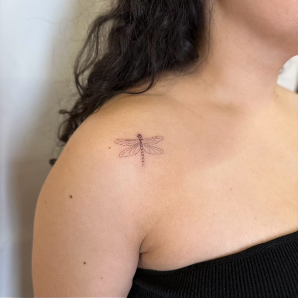 Minimalist Dragonfly Shoulder Tattoo Representing Lightness and New Beginnings 
