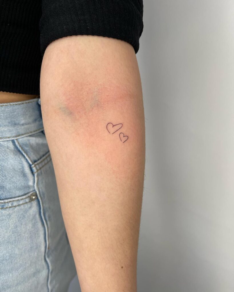 Minimalist fine line cute handwritten love heart on the inner forearm 