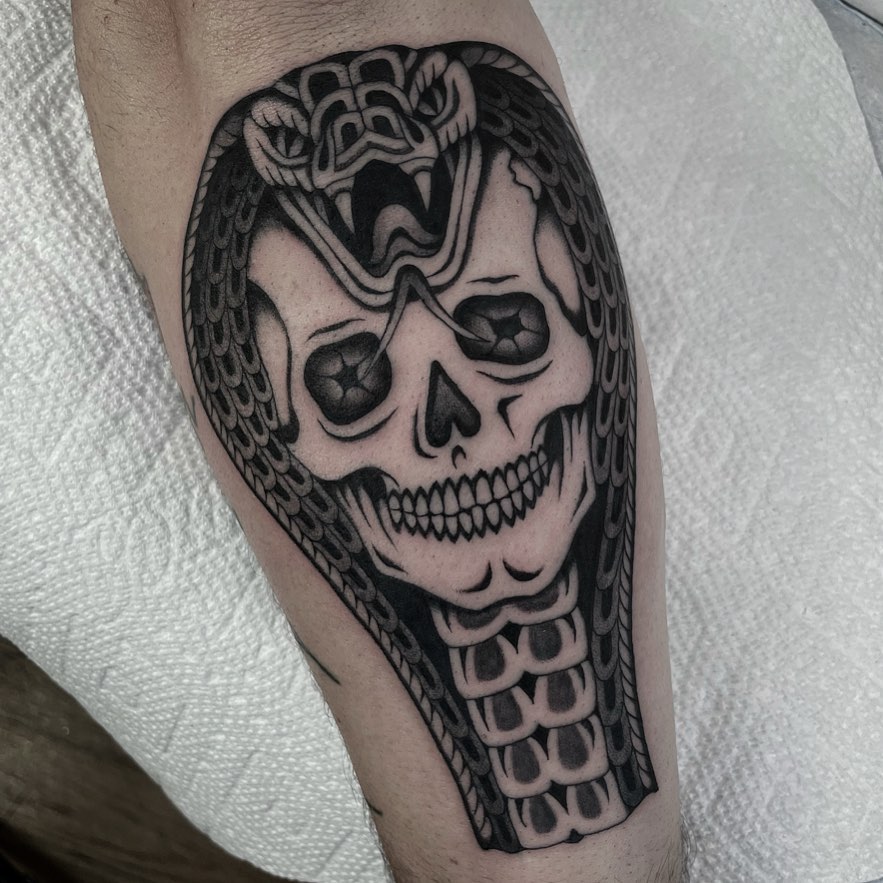 Skull cobra tattoo under the elbow mysterious headpiece in black ink 