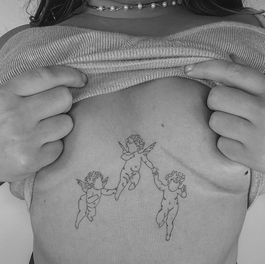Three cherub chest tattoo symbolizing innocence and divine protection 