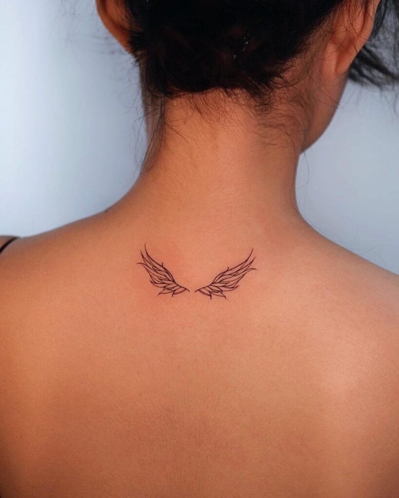 Timeless elegance wings tattoo behind the neck 