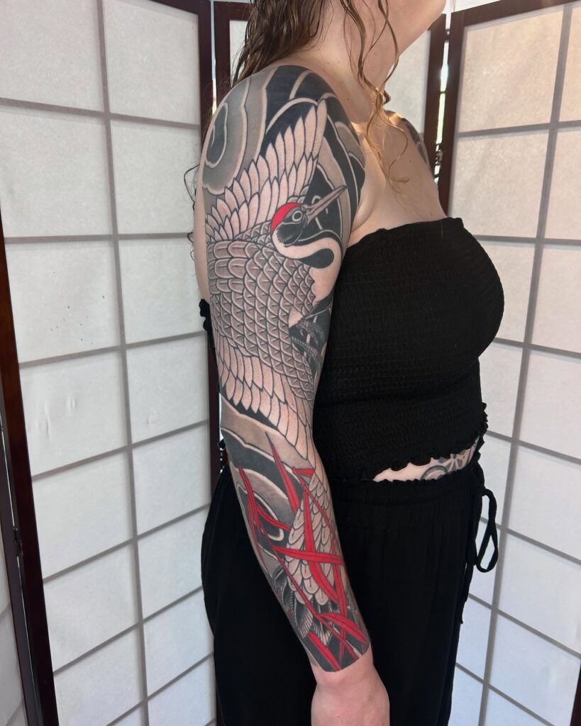 Traditional Japanese Irezumi sleeve tattoo with crane and red accents 