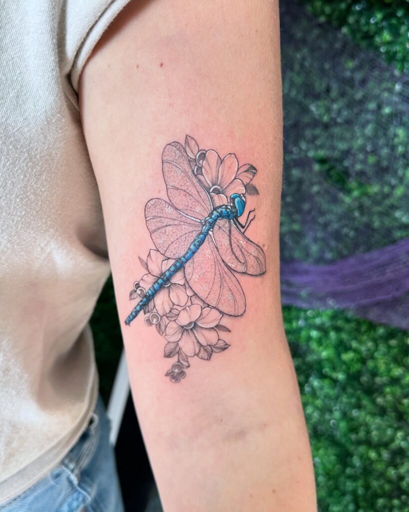 Vibrant Blue Dragonfly Tattoo with Delicate Floral Background 
