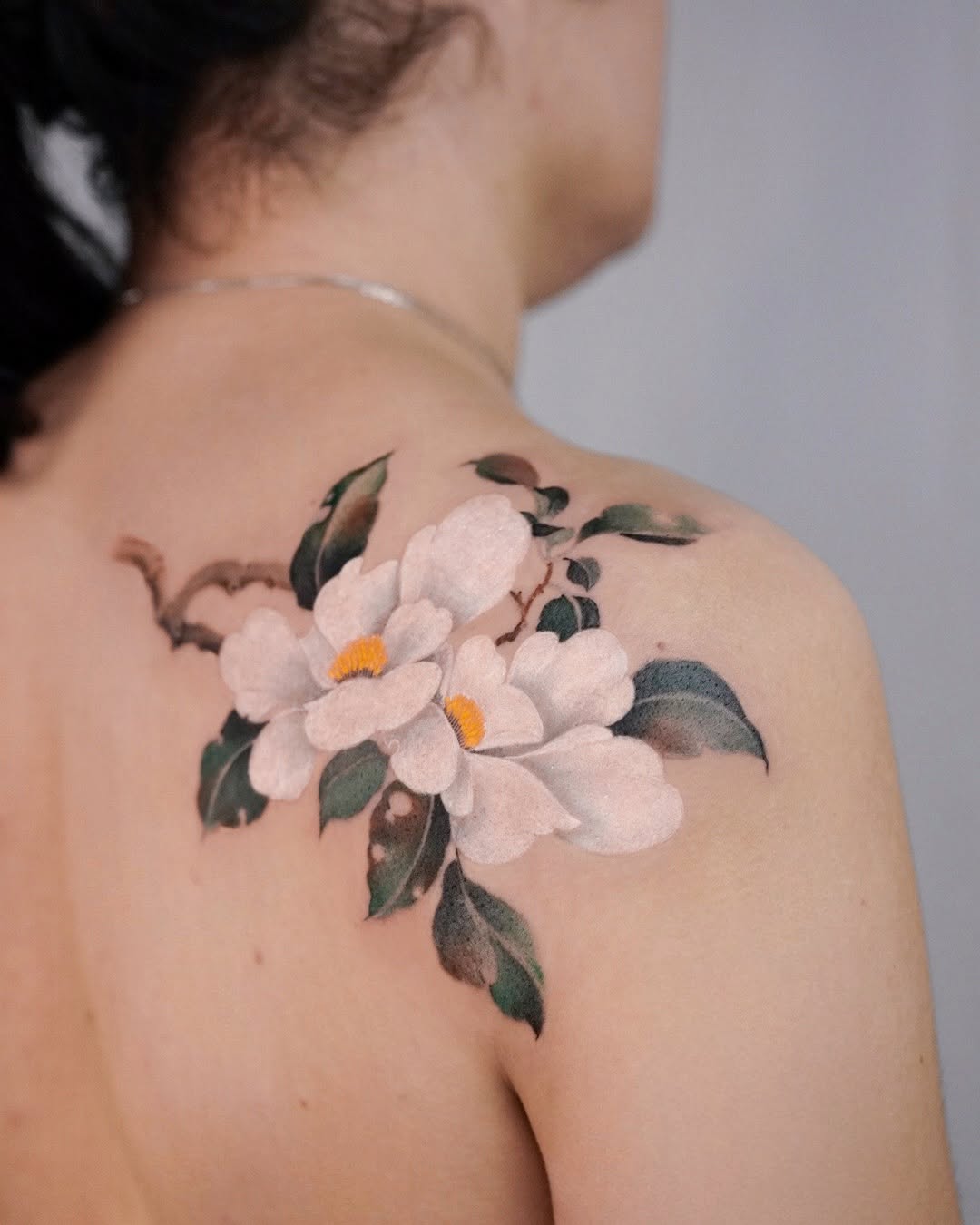Elegant floral watercolor tattoo on shoulder